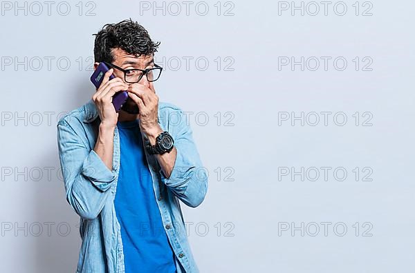 Person secretly talking on the phone. Young man secretly talking on the phone isolated