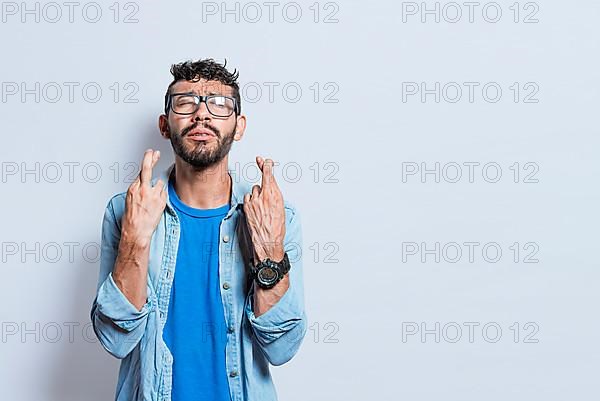 Worried person crossing his fingers making a wish