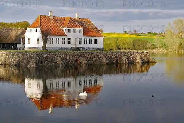 Manor house reflected in the water of a lake