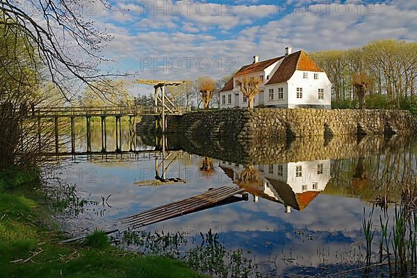 Manor house reflected in the water of a lake