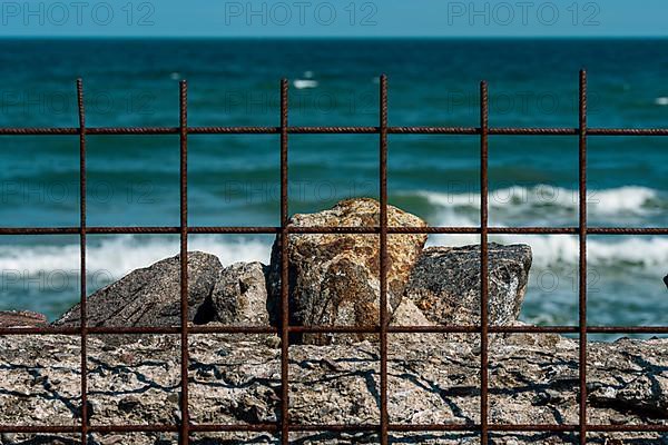 Old firewall with rusty fences on the beach of Prora