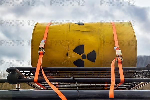 Yellow metal barrel with sign for radioactivity on roof rack