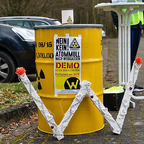 Yellow metal barrel with sign for radioactivity and poster