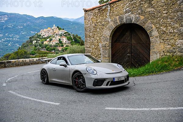 Re-enactment of classic photo of Porsche 911 at historic section of Monte Carlo Rally 1965 with modern supercar sports car Porsche GT3