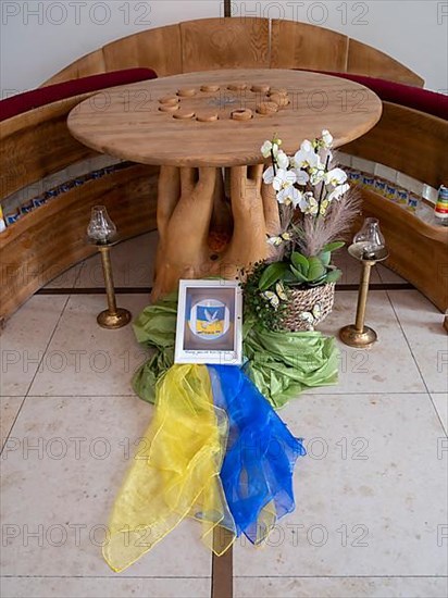 Picture with peace dove and flag of Ukraine on silk cloths in the Ukrainian national colours blue and yellow in the sanctuary of Germany's first private ecumenical motorway church Geiselwind Light on our way on the A 3 between Wuerzburg and Nuremberg