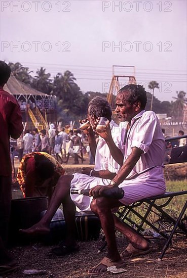 People having tea near an exhibition during Pooram festival in Thrissur or Trichur