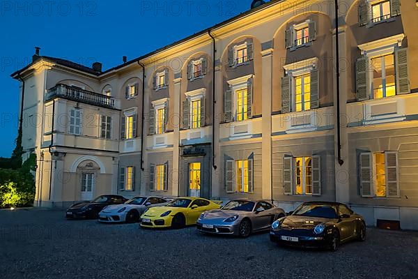Night shot of five Porsche sports cars in representative courtyard of 18th century Hotel Villa Matilde during blue hour