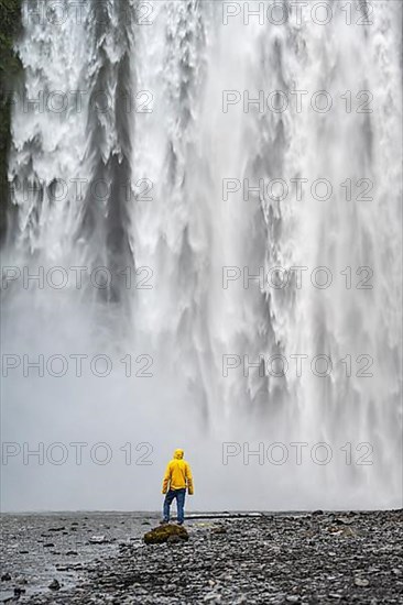Man in front of large waterfall