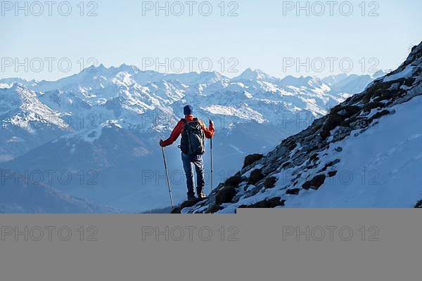 Mountaineers on the rocky summit ridge with the first snow in autumn