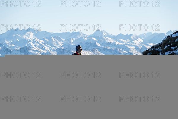 Mountaineers on the rocky summit ridge with the first snow in autumn