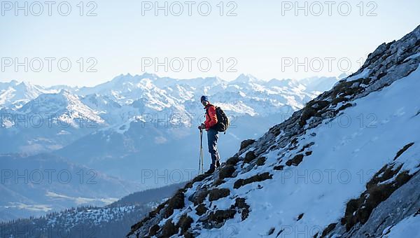 Mountaineers on the rocky summit ridge with the first snow in autumn