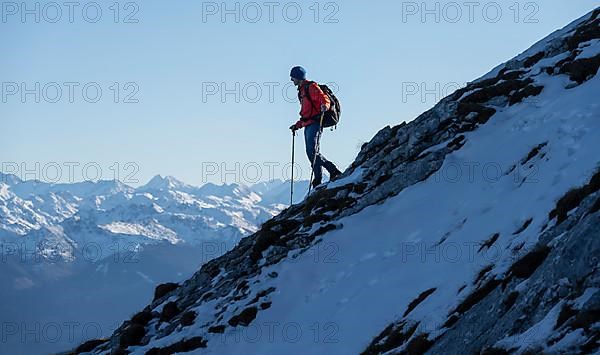 Mountaineers on the rocky summit ridge with the first snow in autumn