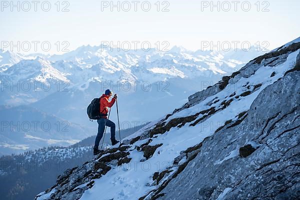 Mountaineers on the rocky summit ridge with the first snow in autumn