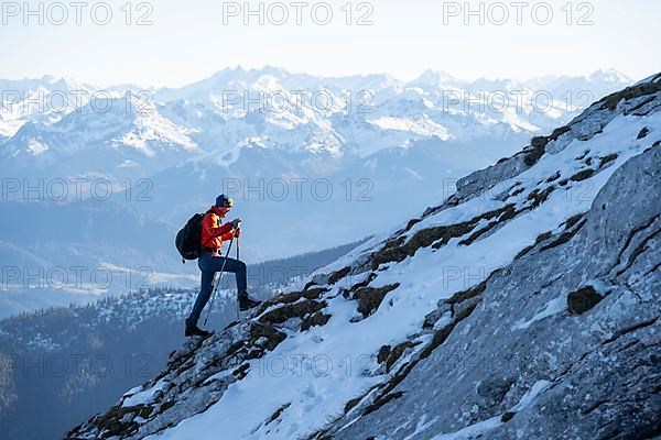 Mountaineers on the rocky summit ridge with the first snow in autumn