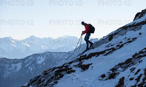 Mountaineers on the rocky summit ridge with the first snow in autumn