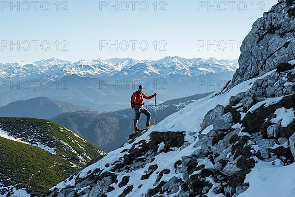 Mountaineers on the rocky summit ridge with the first snow in autumn