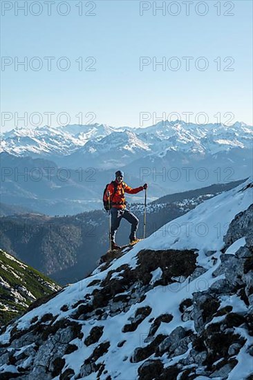 Mountaineers on the rocky summit ridge with the first snow in autumn