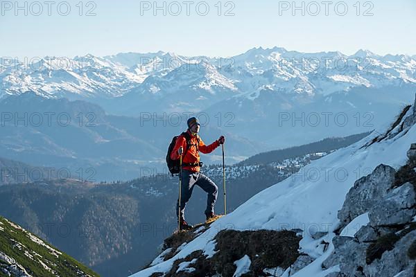 Mountaineers on the rocky summit ridge with the first snow in autumn