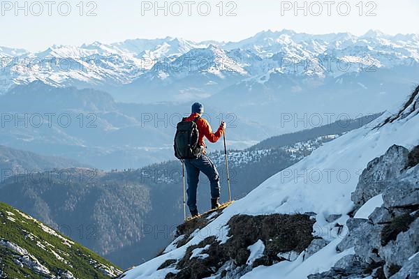 Mountaineers on the rocky summit ridge with the first snow in autumn