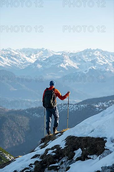 Mountaineers on the rocky summit ridge with the first snow in autumn