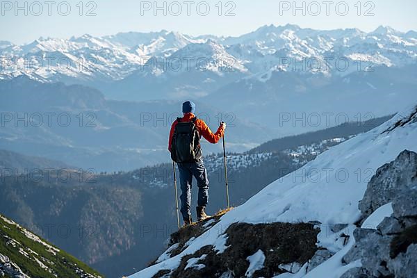 Mountaineers on the rocky summit ridge with the first snow in autumn