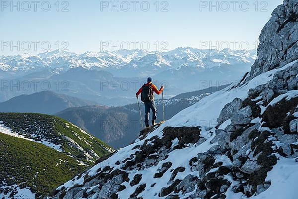 Mountaineers on the rocky summit ridge with the first snow in autumn