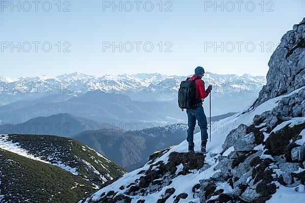 Mountaineers on the rocky summit ridge with the first snow in autumn