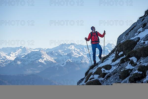 Mountaineers on the rocky summit ridge with the first snow in autumn