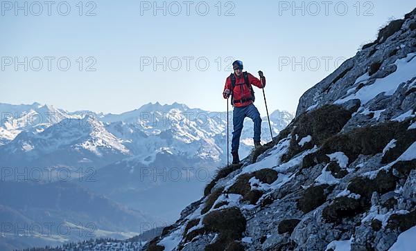 Mountaineers on the rocky summit ridge with the first snow in autumn