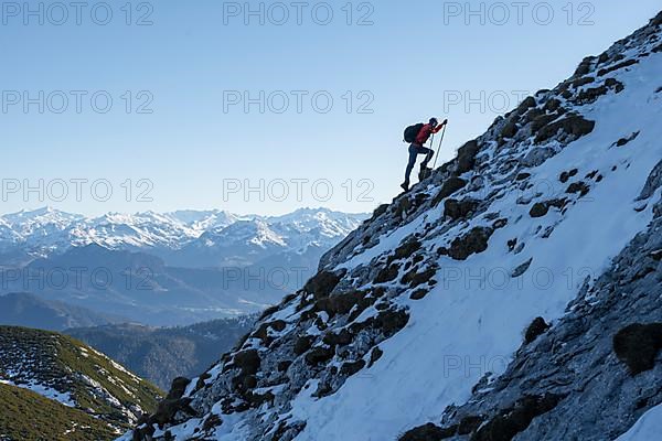 Mountaineers on the rocky summit ridge with the first snow in autumn