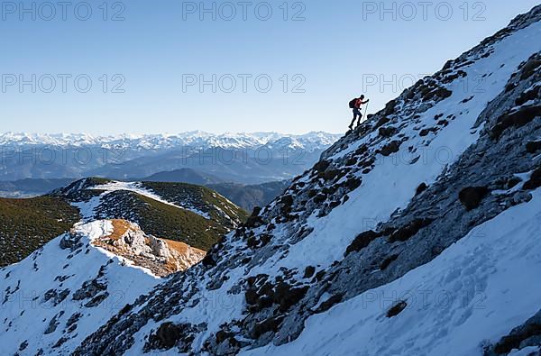 Mountaineers on the rocky summit ridge with the first snow in autumn