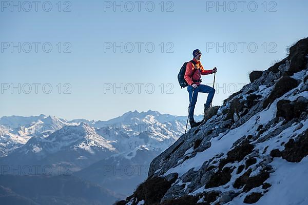 Mountaineers on the rocky summit ridge with the first snow in autumn