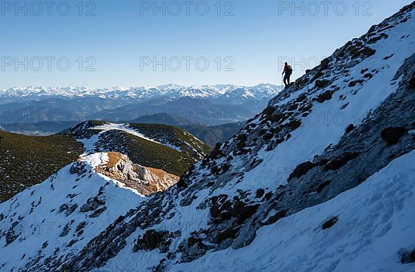 Mountaineers on the rocky summit ridge with the first snow in autumn