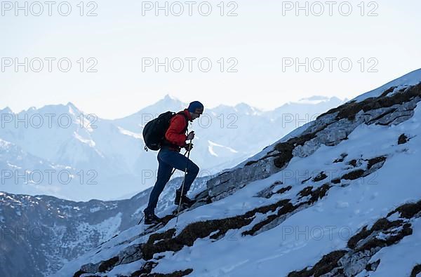 Mountaineers on the rocky summit ridge with the first snow in autumn