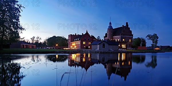 Illuminated castle reflected in a calm body of water