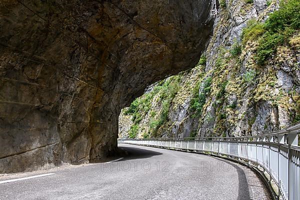 Far overhanging rock face over narrow road in gorge Clue de St-Auban