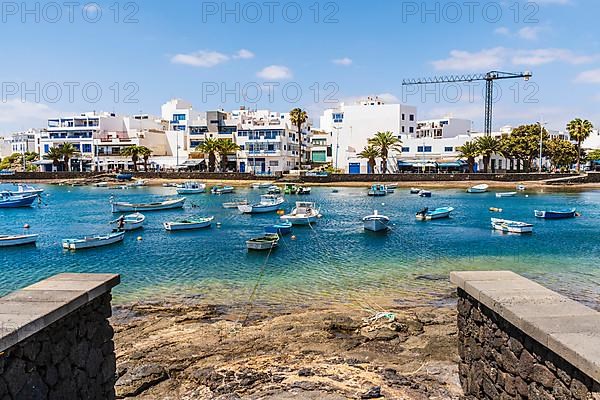 Beautiful seaside downtown of Arrecife with many boats floating on blue water