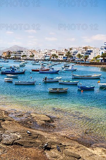 Beautiful seaside downtown of Arrecife with many boats floating on blue water