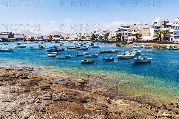 Beautiful seaside downtown of Arrecife with many boats floating on blue water