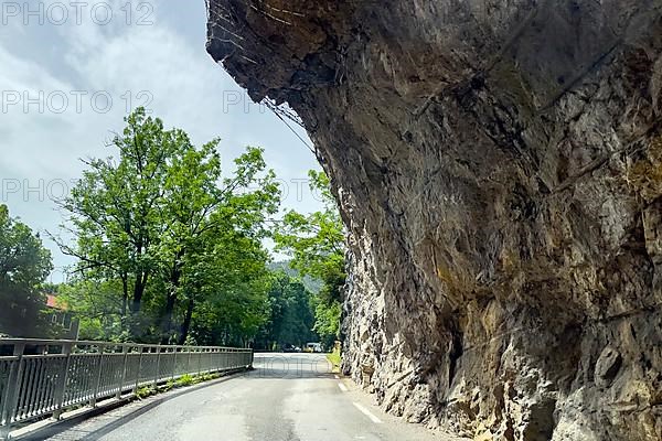 Far overhanging rock face over narrow road in gorge Clue de St-Auban with protection against falling rocks