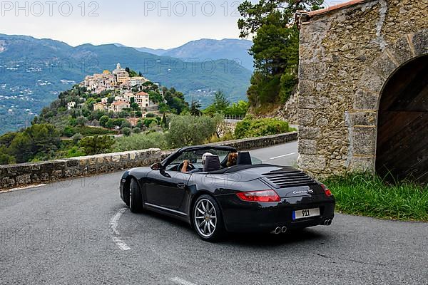 Sports car convertible Porsche 911 in tight curve of historic track section of Rallye Monte Carlo 1965