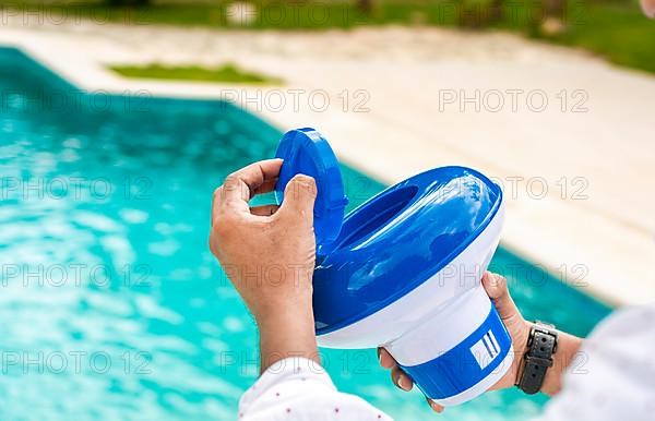 Hands of a worker installing a pool chlorine float