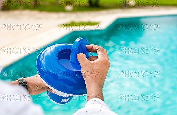Hands of a worker installing a pool chlorine float