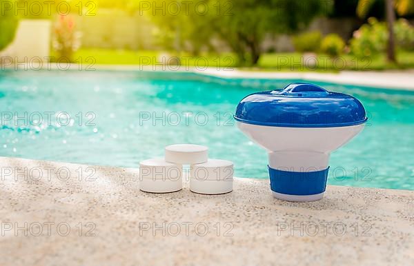 A pool float and chlorine tablets on the edge of a swimming pool. Tablets with chlorine dispenser for swimming pools. Chlorine tablets with dosing float