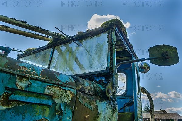 Old car rolled for scrapping in a meadow. Alsace