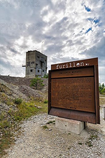 Abandoned industrial building and rusty iron welcome sign