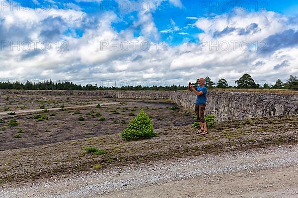 Tourist photographs abandoned quarry