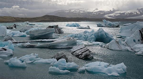 Lake Joekulsarlon with turquoise ice chunks and mountains in the background