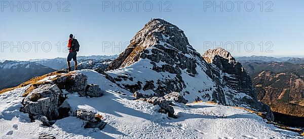 Climbers on the rocky summit ridge with first snow in autumn