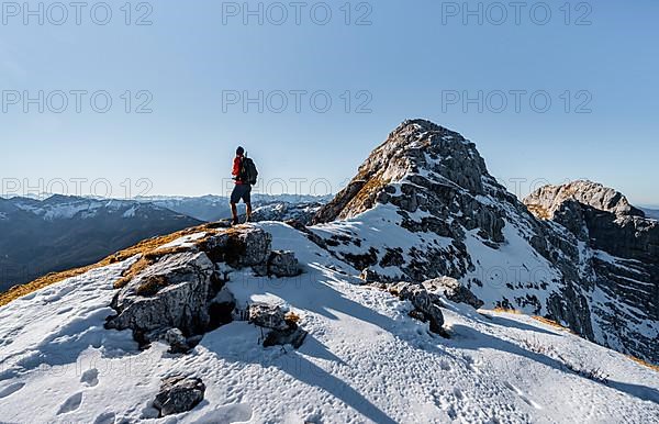 Climbers on the rocky summit ridge with first snow in autumn